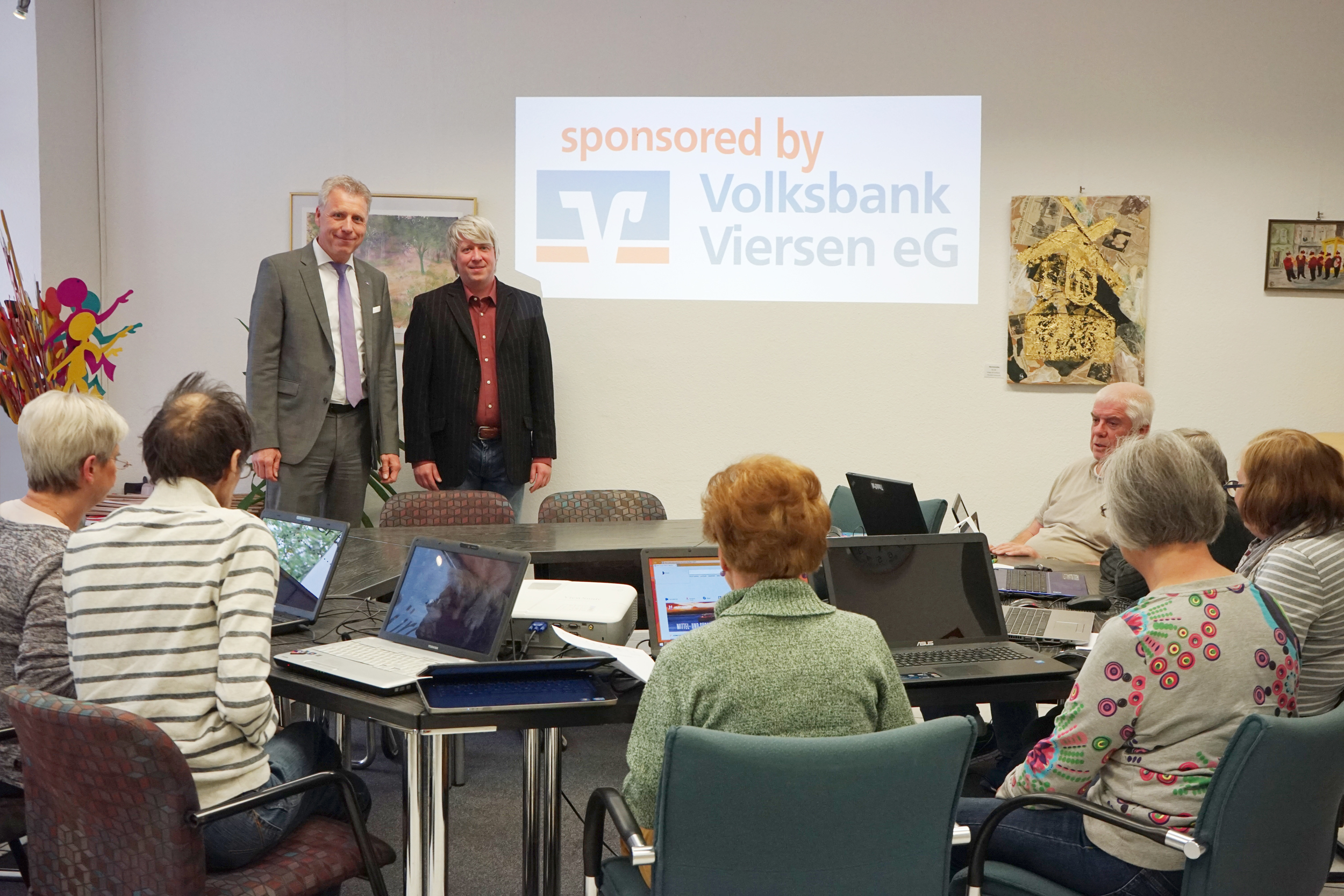 Volksbank-Vorstand Jürgen Cleven übergibt den neuen Beamer an Andreas Goßen vom DülkenBüro