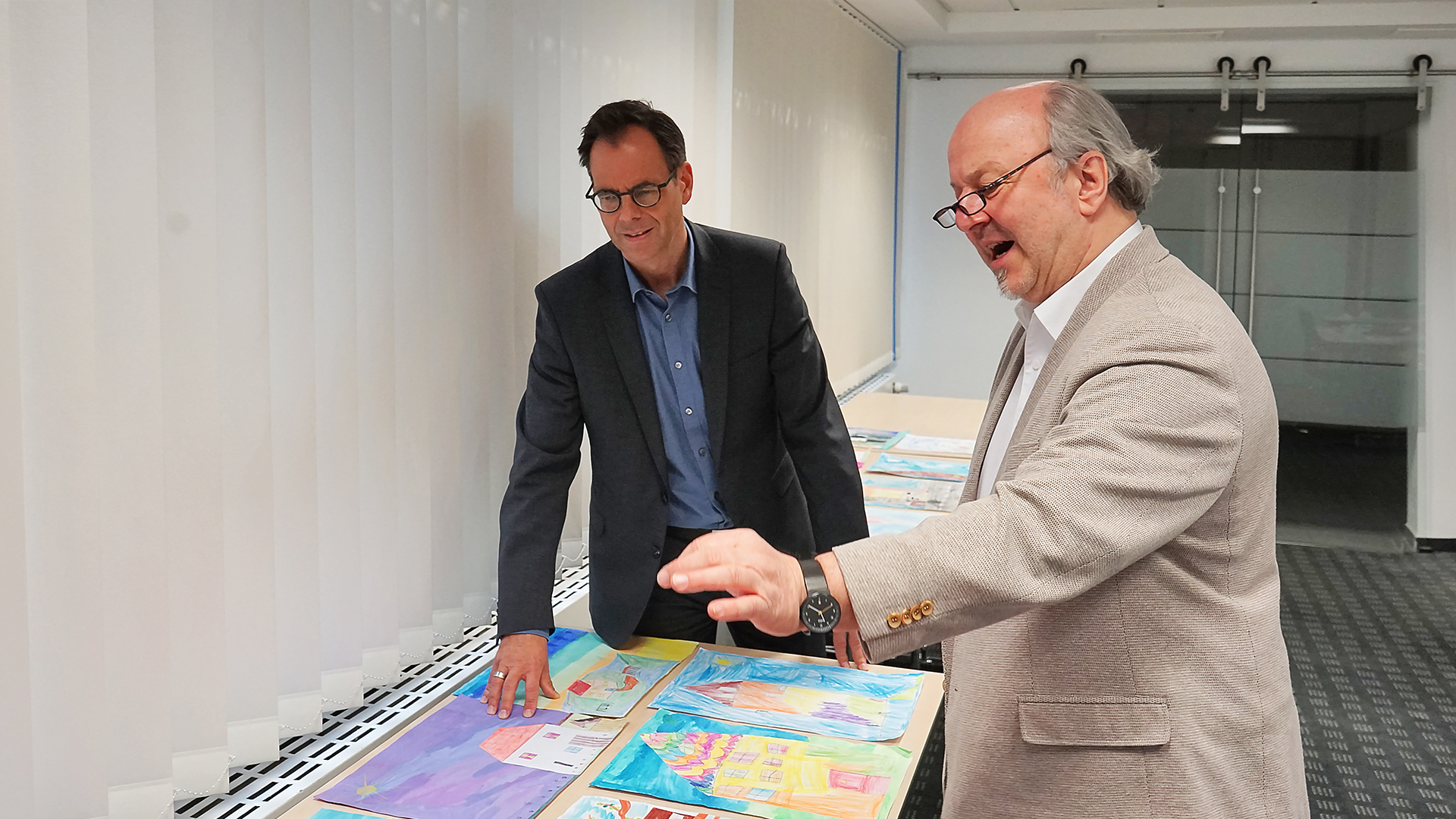 Michael Willemse, Vorstand der Volksbank Viersen, und Uwe Peters, Viersener Künstler und Mitorganisator des Kunstfestivals viersen°openart, bei der Jurierung der eingereichten Arbeiten.