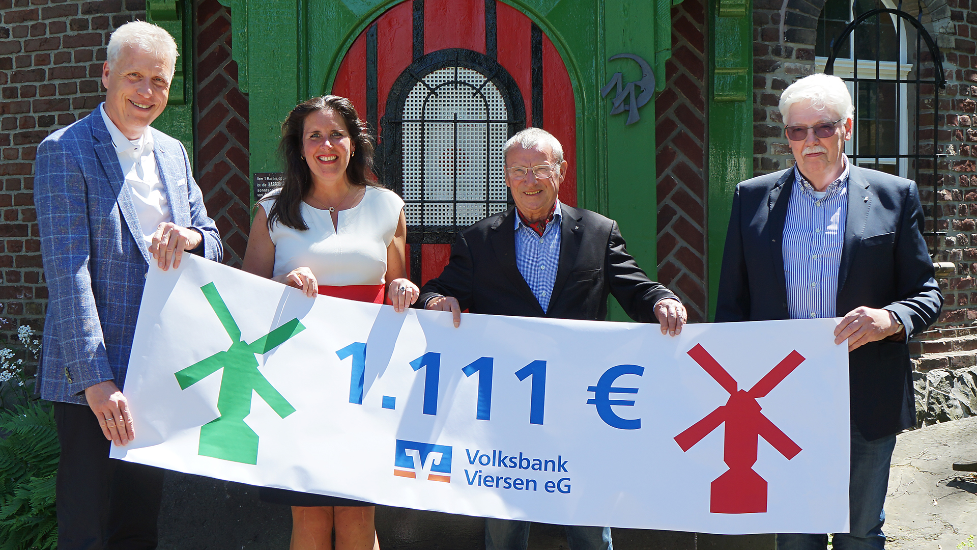 Die Volksbank Viersen spendet 1.111 Euro für den Wiederaufbau der Narrenmühle. Jürgen Cleven (Vorstand der Volksbank Viersen), Simone Gartz (Ortsbürgermeisterin von Dülken), Dr. Volker Müller und Hartwig Hören (Förderverein der Narrenmühle) freuen sich, dass die Mühle wieder aufgebaut wurde.
