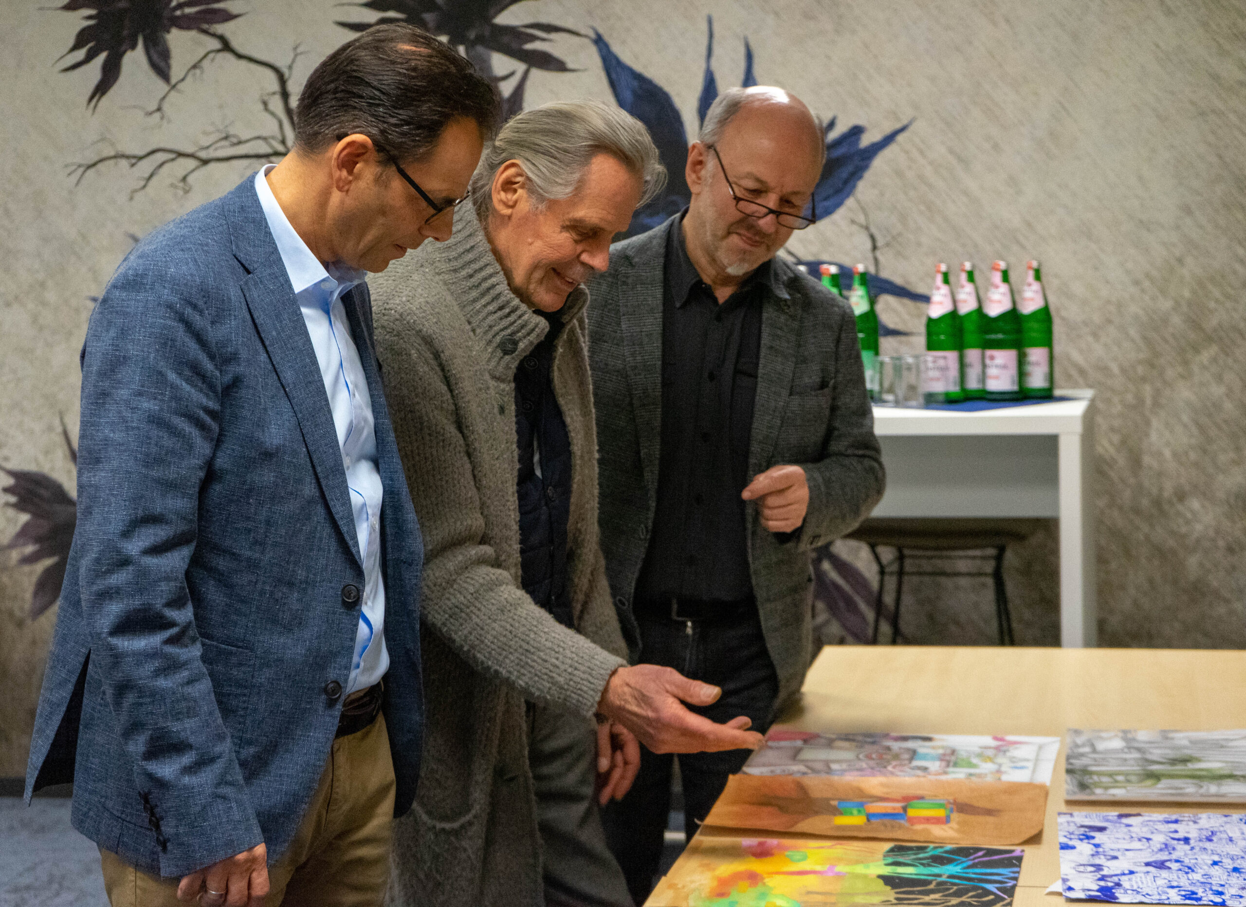 Michael Willemse (Vorstand der Volkbank Viersen), Emil Schult und Uwe Peeters (beide Künstler und Mitorganisatoren den Kunstfestivals viersen°openart sichten die Bilder.
